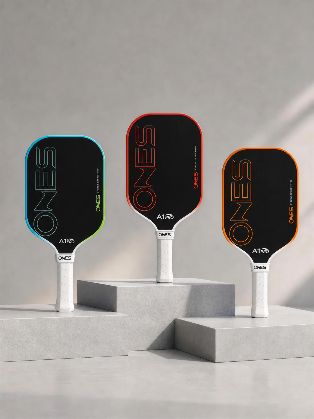 Three ONES A1 Pro paddle colorways displayed on sculpted plinths
